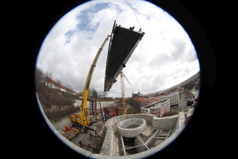 22.02.2022, Erfurt, Lauentor, Bastionskronenpfad, fuer die Mauerkronenbruecke / Mauerkronenbrücke wird das zweite und groesste Brueckensegment / Brückensegment eingehoben, dies ist der erste Bauabschnitt vom Bastionskronenpfad das Segment schwebt am Kran Foto: Karina Hessland-Wissel