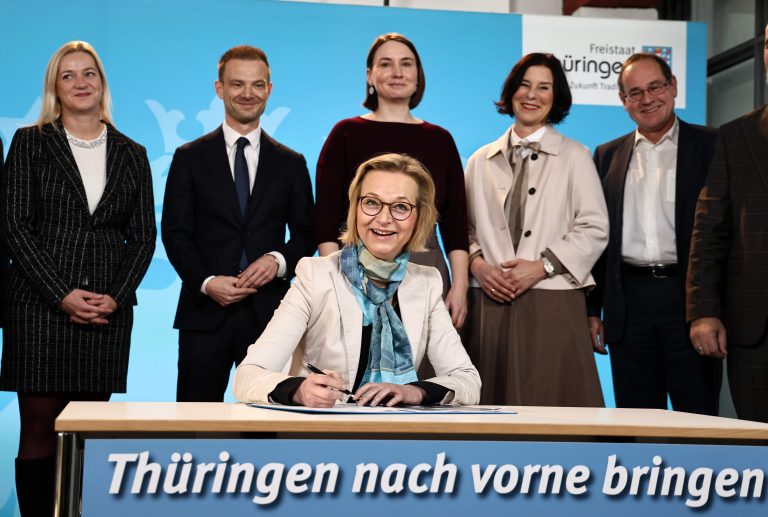 21.01.2025, Erfurt, Thueringer Staatskanzlei, Unterzeichnung des 100-Tage-Programms im Anschluss an die Kabinettsitzung im Bild: Finanzministerín Katja Wolf (BSW) unterschreibt das Papier, dahinter Ministerin fuer Justiz, Migration und Verbraucherschutz Beate Meissner (CDU) , Chef der Staatskanzlei und Minister für Bundes- und Europaangelegenheiten, Sport und Ehrenamt Stefan Gruhner (CDU) , Ministerin fuer Arbeit, Soziales, Gesundheit und Familie Katharina Schenk (SPD) , Ministerin fuer Wirtschaft, Landwirtschaft und Laendlichen Raum Colette Boos-John (CDU) , Minister fuer Umwelt, Energie, Naturschutz und Forsten Tilo Kummer (BSW) Foto: Karina Hessland-Wissel